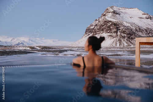 Woman relaxing in hot spring with snowy mountain view