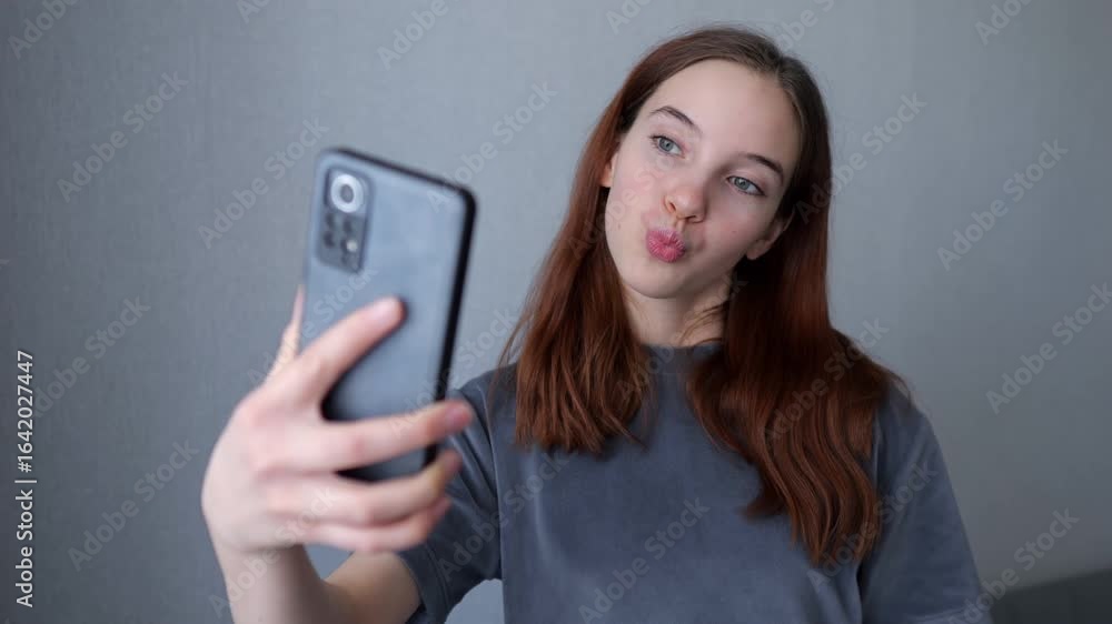 Teenager posing for selfies on smartphone at home Teenager posing for selfies on smartphone at home