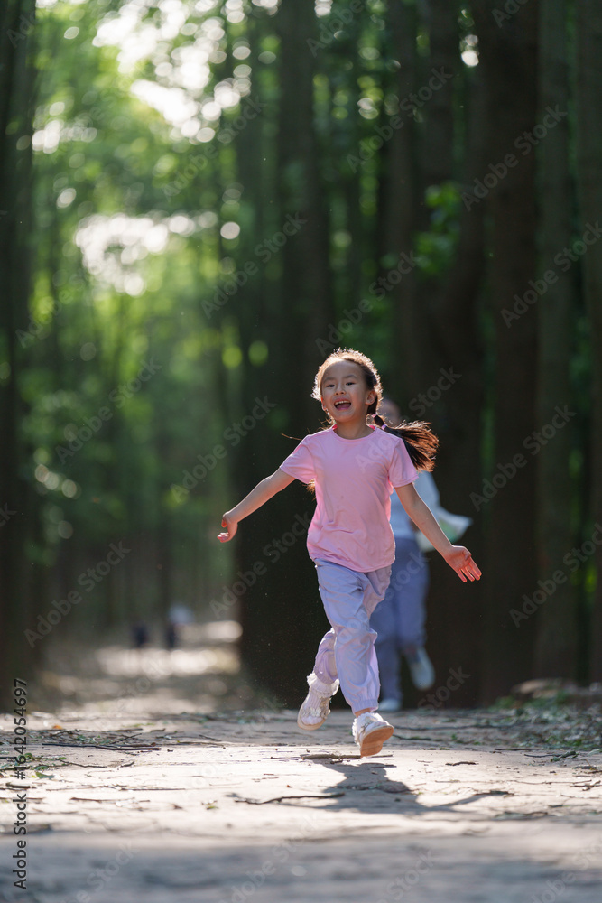 Happy little Asian girl running on a sunny forest path Happy little Asian girl running on a sunny forest path