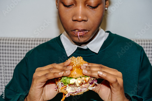 Close-up of woman eating juicy burger
