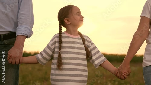 Family holding hands sunset, Happy child girl with parents outdoors, Childhood mother father happiness family, Togetherness love nature, Parents daughter enjoy evening, Smiling girl striped shirt