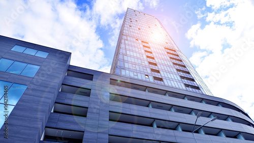 Looking up blue modern office building. The glass windows of building with  aluminum framework.