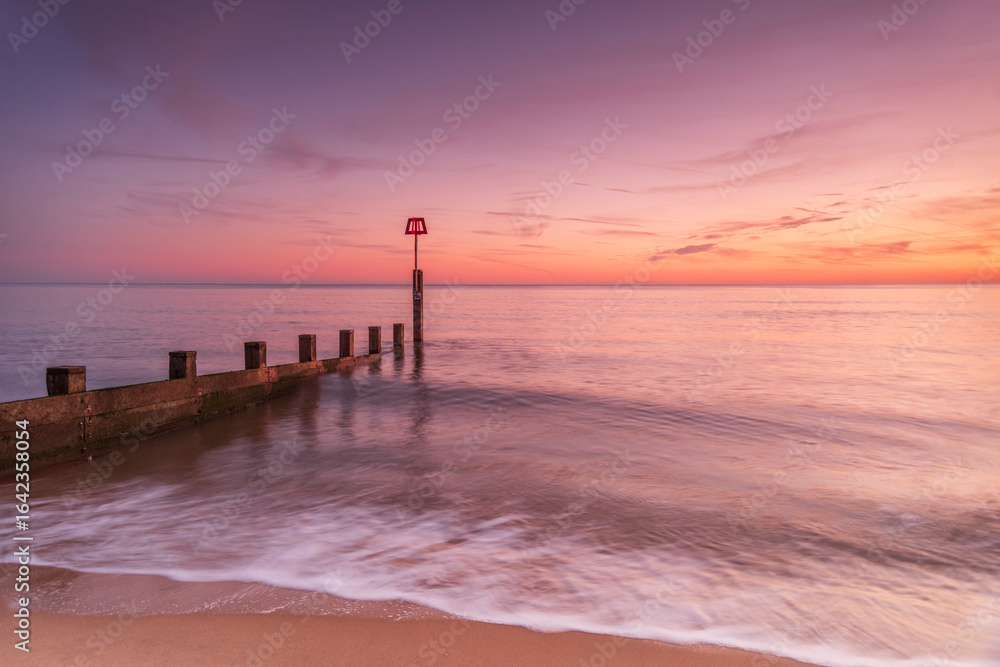 Fototapeta premium Bournemouth beach illuminated by the setting sun at sunset