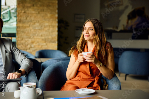 Woman drinks coffee in the hotel lobby
