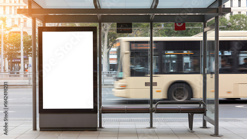 Blank billboard at bus stop in city with bus passing by, perfect for ads