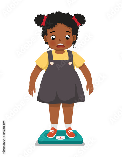 overweight little girl with body fat standing on the weighing scale look surprise when measuring her weight
