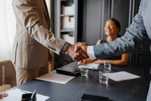 Business people shaking hands after closing a deal in lawyers office