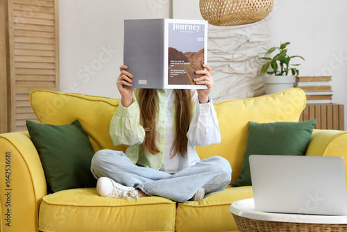 Young woman reading magazin...