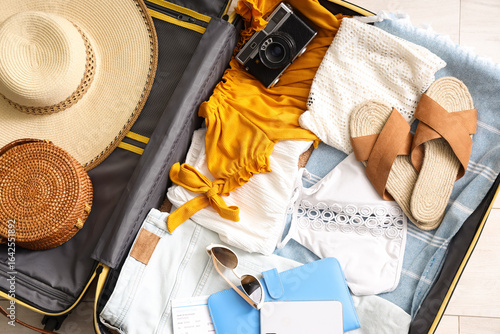 Open suitcase with clothes,...
