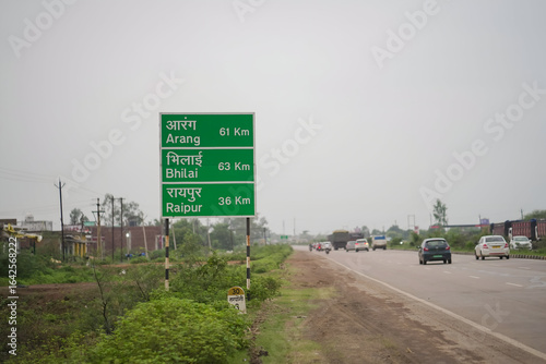indian highway distance signboard bhilai aarang raipur, green road direction sign india, national highway travel guide board, rural expressway milestone signage stock photo.