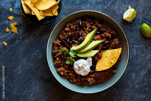 Beef chili with avocado, sour cream and tortilla chips