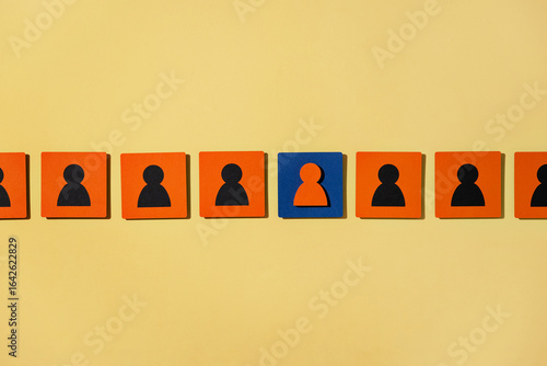 Colorful blocks depict teamwork and leadership on yellow background