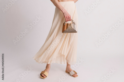 Elegant Beige Pleated Skirt with Stylish Accessories