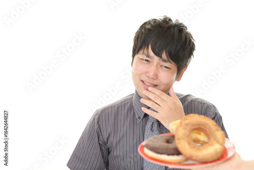 甘い食べ物を我慢する男性