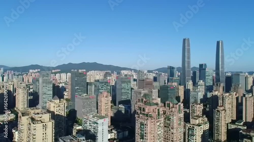 Wallpaper Mural Aerial view of a bustling city skyline with modern skyscrapers and distant mountains under clear blue sky Torontodigital.ca