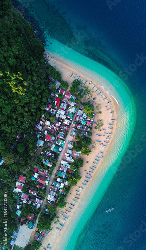 Drone shot of pristine coastline with white sand and clear blue waters.