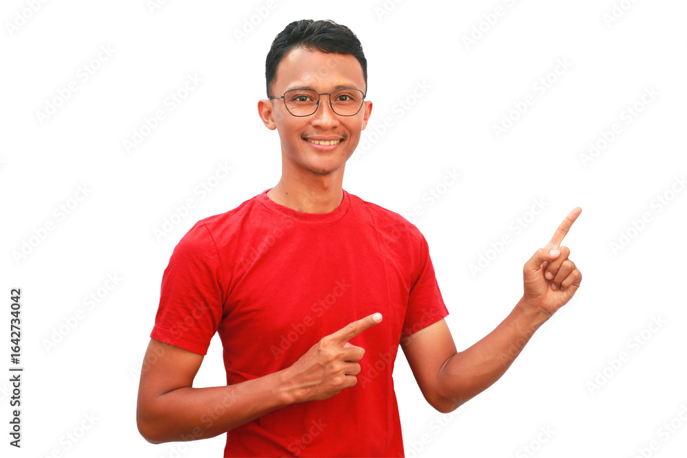 Naklejka premium An Asian man wearing a red shirt points upwards with a happy expression.