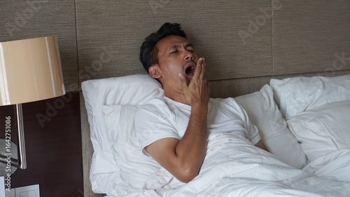 Tapety artystyczne asian man yawn at the bed