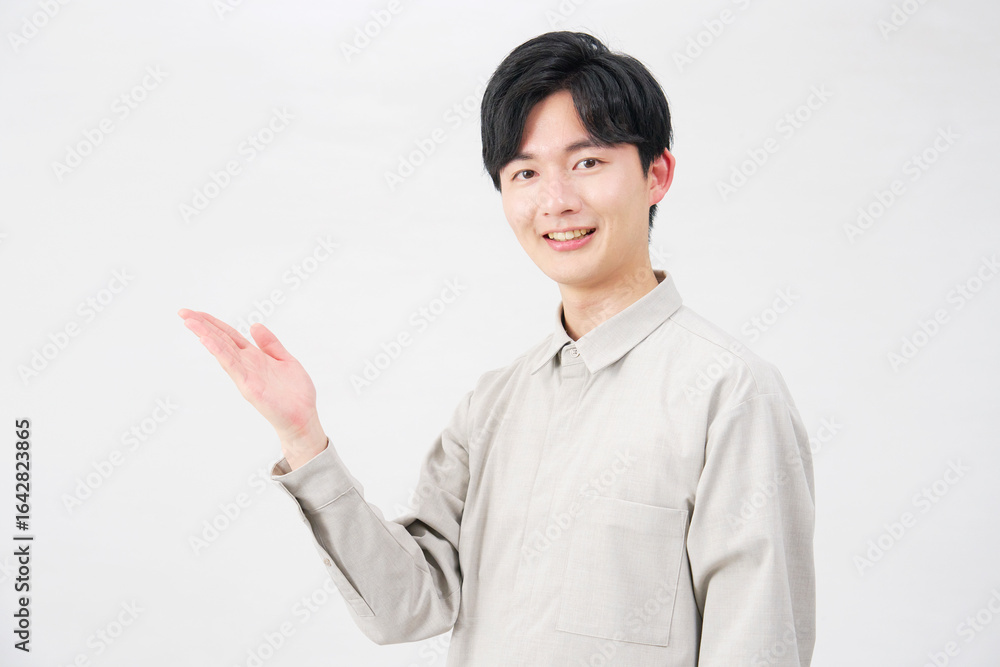 手のひらで左側を指す男性 20代 白背景 手のひらで左側を指す男性 20代 白背景