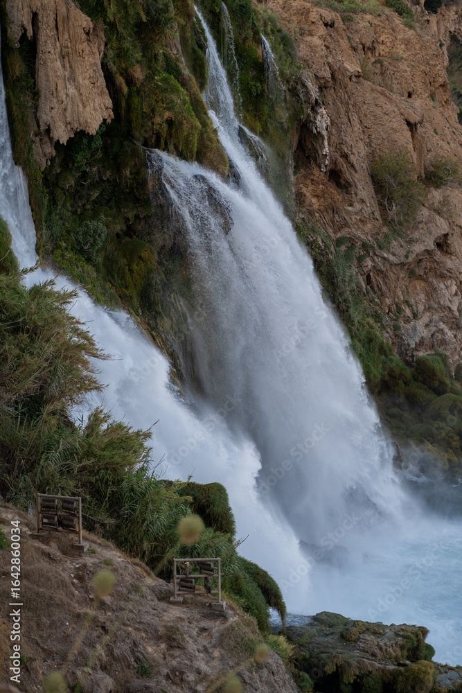 Fototapeta premium Majestic Waterfall Cascading Over Rocky Cliffs at Sunset in a Serene Natural Landscape