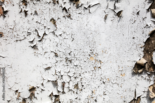 A wall with peeling paint and a lot of cracks