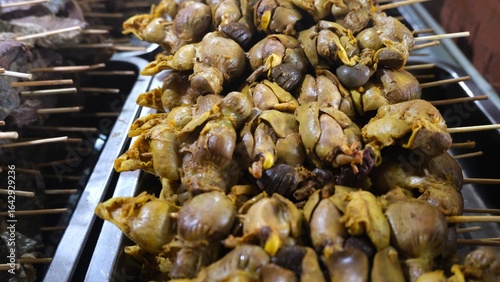 Bild auf Leinwand Close-up of skewered chicken offals, seasoned and cooked, arranged on a tray as part of a traditional Indonesian food selection