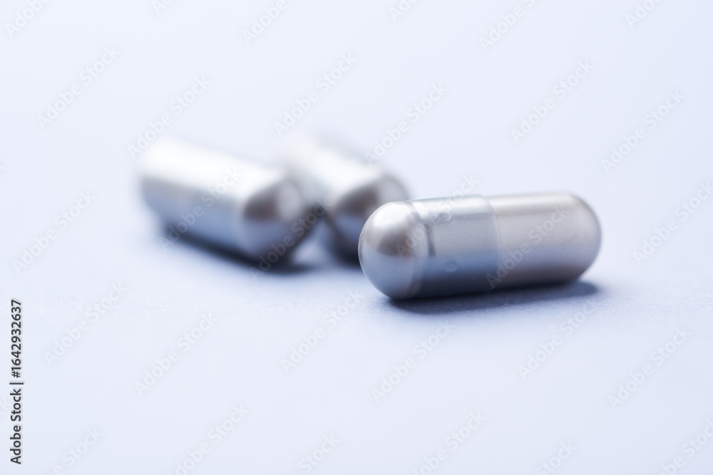 Naklejka premium Amino acids capsules on bright background. Soft focus. Close up. Copy space. 