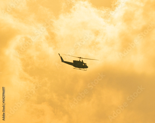 Camouflage colour bell 212 helicopter in hover over a large water tank and ready for departure	