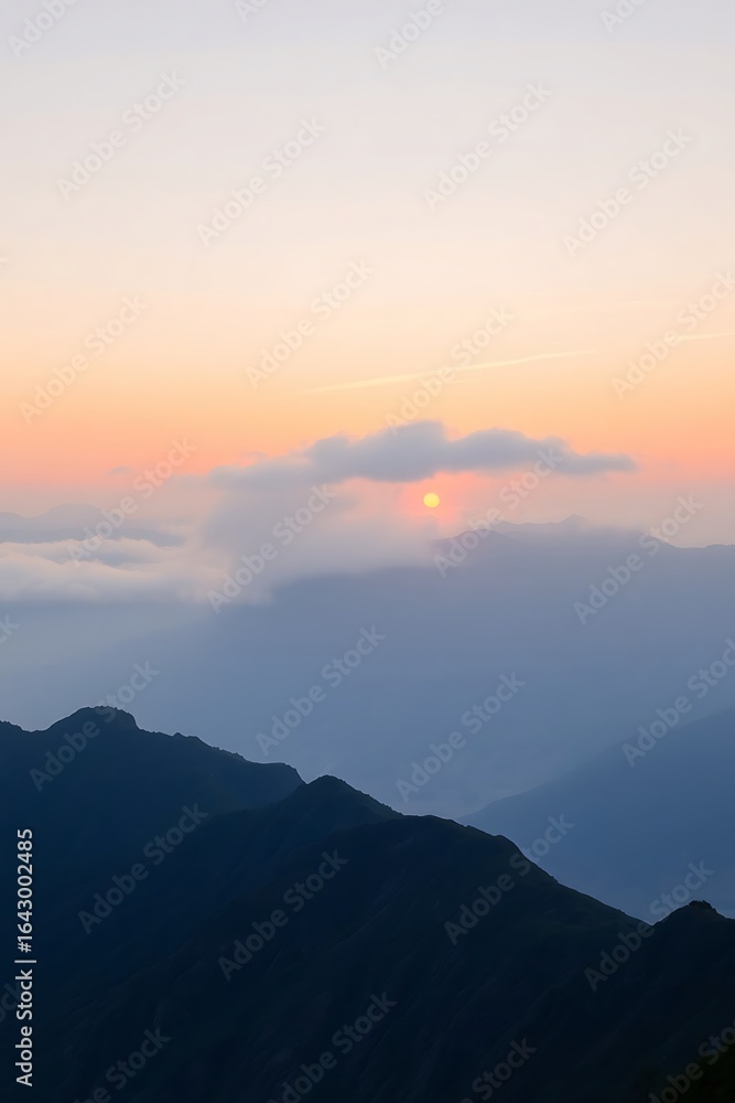 Fototapeta premium Sunset Over Mountain Range with Clouds and Layered Blue Hues