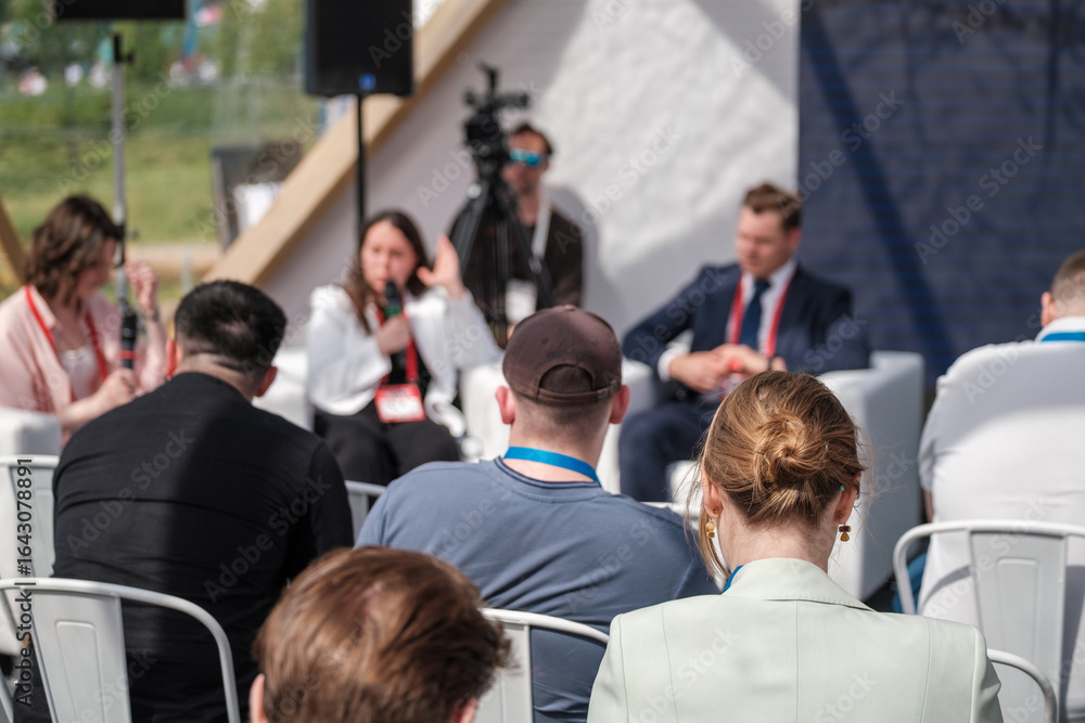 Group of professionals engaging in seminar event. Attendees focus on speaker discussions indoors. Group of professionals engaging in seminar event. Attendees focus on speaker discussions indoors.