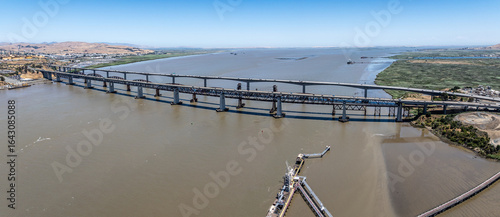 panoramic aerial landscape view of area around Carquinez Strait with Benicia-Martinez Railroad Bridge and Benicia–Martinez Bridge (680) with traffic running in both directions