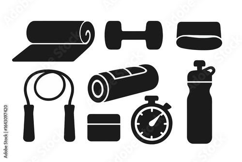 Fitness equipment arranged on a plain background showcasing exercise essentials for a workout session at home