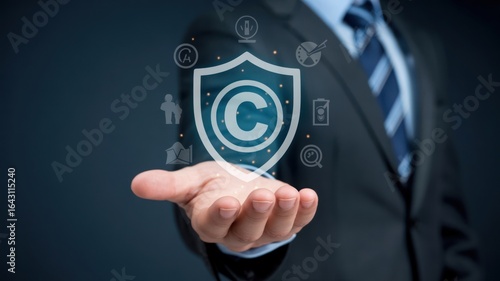 Businessman protecting intellectual property with a digital shield