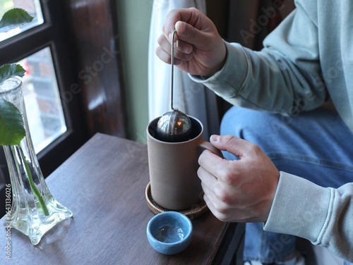 Man drinking tea in cafe, closeup. vintage mood
