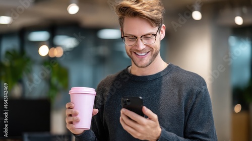 Wallpaper Mural Smiling Young Man Holding Pink Coffee Cup and Black iPhone in Modern White Office Space. Torontodigital.ca