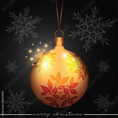 A beautiful golden ornament adorned with an elaborate leaf-floral design on a black backdrop with scattered snowflakes.