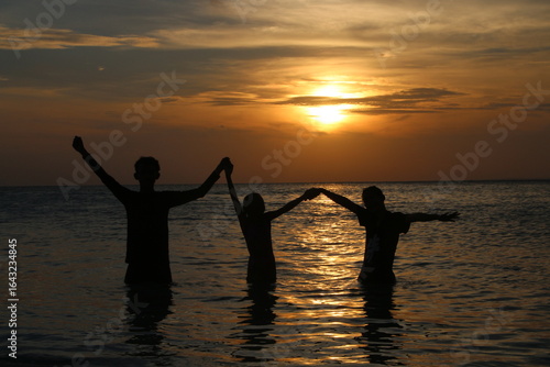 Wallpaper Mural Silhouette of a couple making heart shape with hands in the sea at sunset, perfect for romantic and travel themes Torontodigital.ca