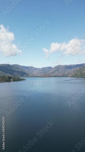 Wallpaper Mural Aerial view of the tranquil lake mirroring the clear sky, framed by rugged hills, creates a serene contrast of blues and browns, Lago de Sanabria, Castile and León, Spain. Torontodigital.ca