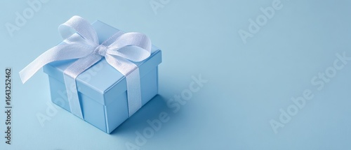The elegant blue gift box with a ribbon on a pastel background.