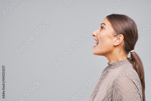 Foto Side profile of smiling woman looking up with open mouth in studio