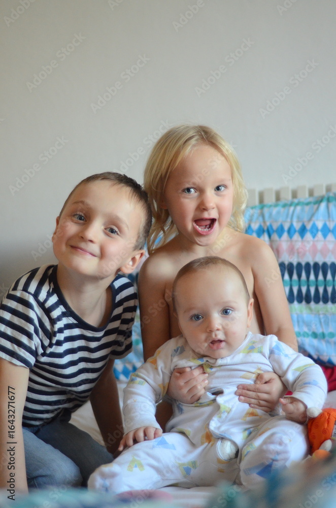 Happy Siblings and Baby Smiling Together Happy Siblings and Baby Smiling Together