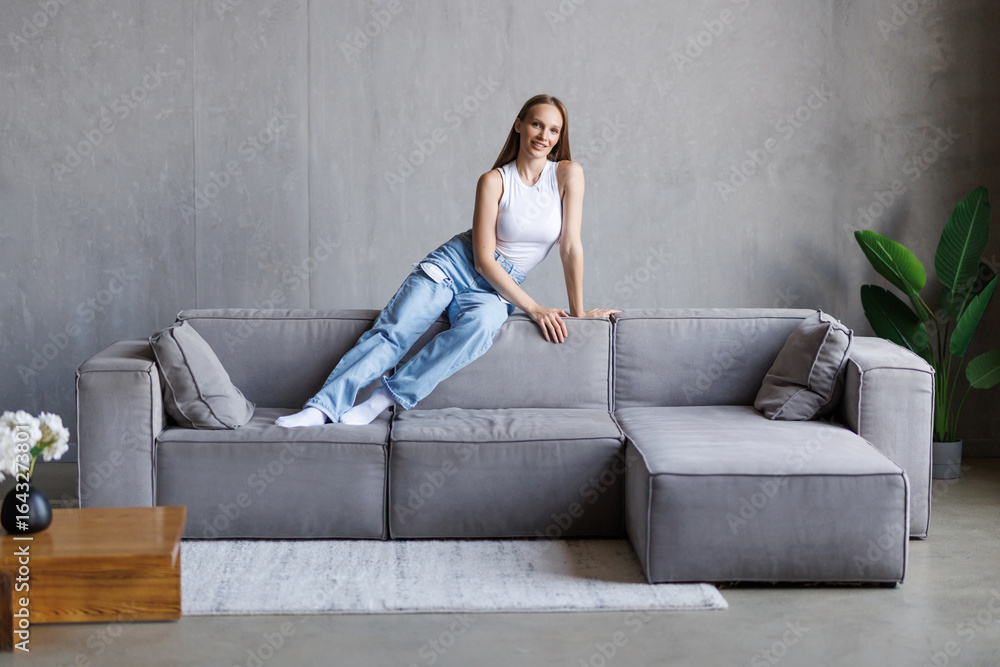 Obraz premium Young woman stand on the couch at home
