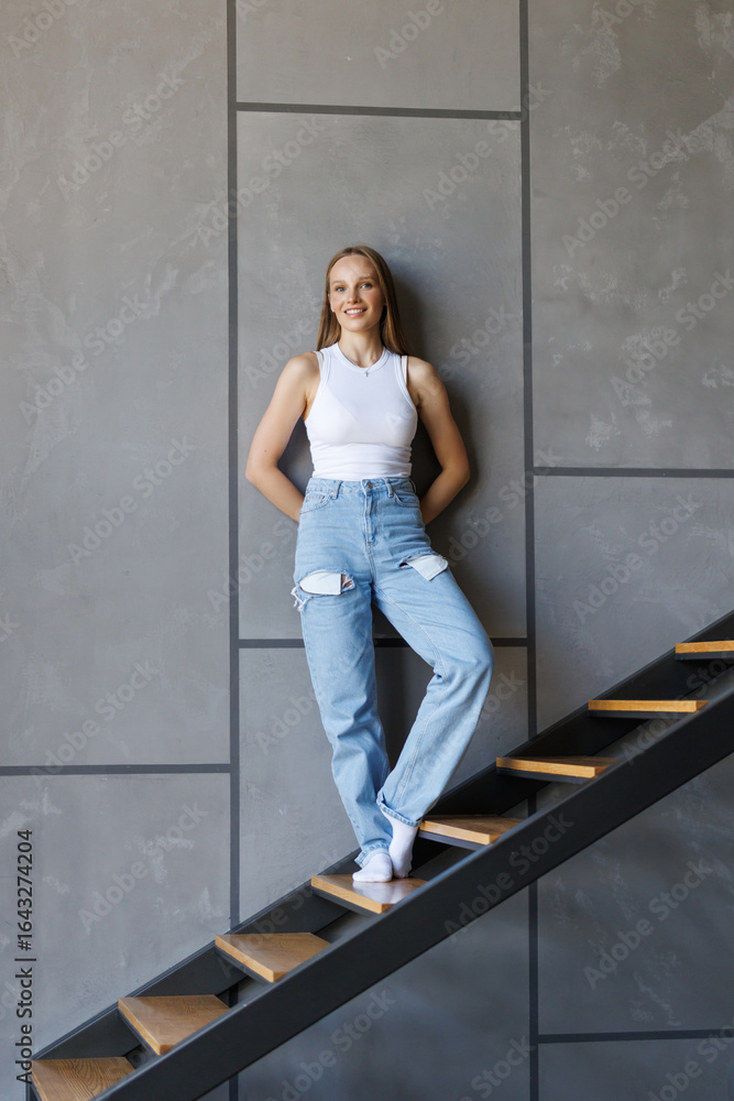 Fototapeta premium Young woman standing on a home stairs