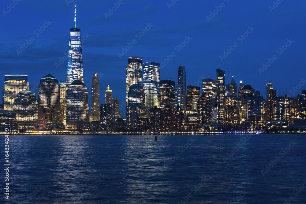 Obraz premium City skyline illuminated at night, with sparkling lights and towering buildings