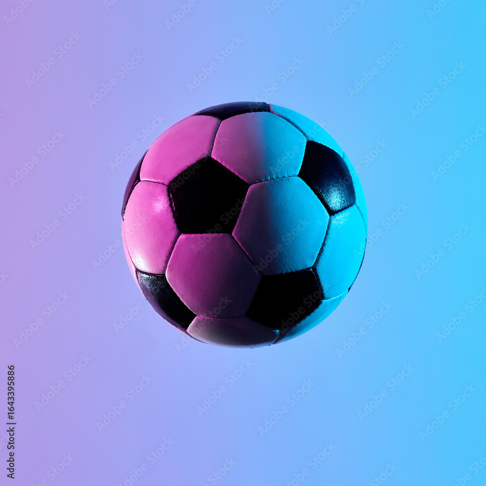 Naklejka premium Close-up floating soccer ball in vivid neon light. Concept of sports equipment, game essentials, brand marketing, and visual storytelling for professional and creative purposes.