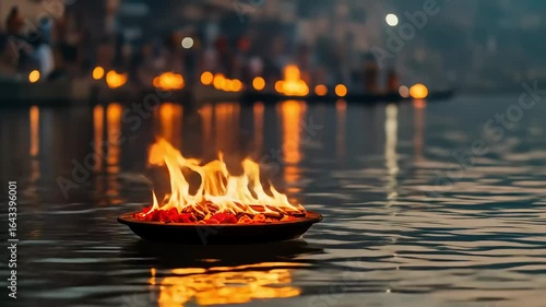 Burning Flames in a Bowl Floating on Reflective River Water Under Dark Sky Offering Traditional Ceremony in India