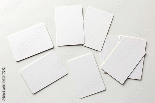 Blank white cards scattered on a clean white surface offering room for text