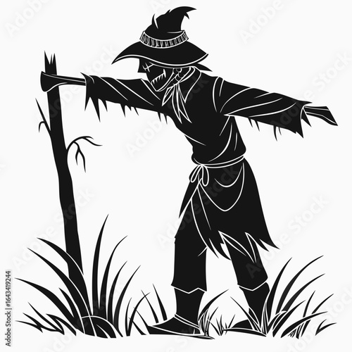 Scary silhouette scarecrow with tattered clothes on a pole in tall grass