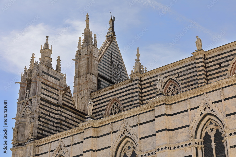 Naklejka premium View from Piazza Jacopo della Quercia to the Duomo or Cathedral SE side and rear of the facade upper part by Camaino di Crescentino. Siena-Tuscany-194