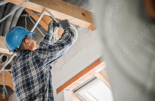 Electrician Performing Wiring Installation in a Modern Home Renovation Project